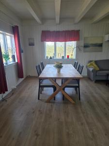 a room with a wooden table and chairs and a couch at Cabin in Leirvåg in Leirvåg +8 photos