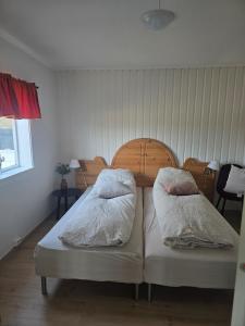two beds with pillows on them in a bedroom at Cabin in Leirvåg in Leirvåg