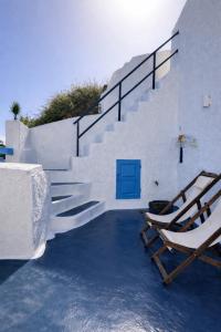 a staircase with a chair and a blue door at Tiara hideaway house in Éxo Goniá