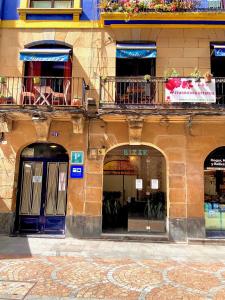 a building with two arches and a blue door at Iturrienea Ostatua in Bilbao