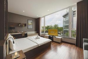 a hotel room with a bed and a large window at Amy Apartment Hue in Hue