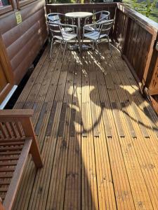 a wooden deck with a table and chairs on it at Fernleys Place in Trawsfynydd
