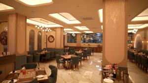 a dining room with tables and chairs in a restaurant at Hotel Roma Kristo in Dwarka
