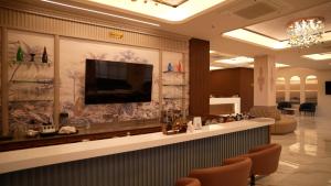 a lobby with a bar with a tv on the wall at Hotel Roma Kristo in Dwarka