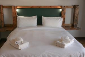 a white bed with two towels on top of it at Heydays B&B in Noupoort