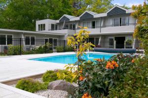 a house with a swimming pool in front of it at Anchorage Resort Taupo NZ in Taupo