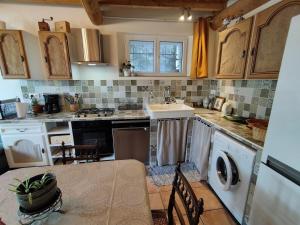 a kitchen with a sink and a washing machine at à 10 mn des Gorges de l'Ardèche in Bidon +14 photos