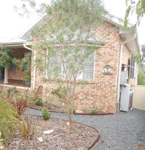 a small tree in front of a brick house at The Honeypot in Balmoral