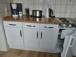 a kitchen with white cabinets and a counter top at Pension Villa Sophia in Sassnitz