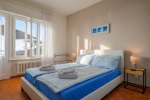 a bedroom with a bed with blue sheets and a window at Al Pianaccio by Lago Reisen in Trarego Viggiona
