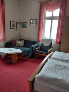 a hotel room with a bed and a couch at Pension Villa Sophia in Sassnitz