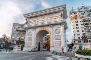 a large building with an arch in a city at Atlas Hostel in Skopje