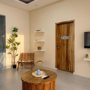 a living room with a table and a wooden door at CASA Habibi in Kuta Lombok