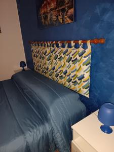a blue bedroom with a bed with a pillow on it at A due passi dal mare in Capo dʼOrlando