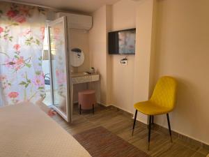 a bedroom with a yellow chair and a mirror at City Suites Budva in Budva