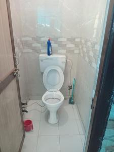 a bathroom with a toilet with a bottle on top of it at Shri Shyama seva kunj in Vrindāvan
