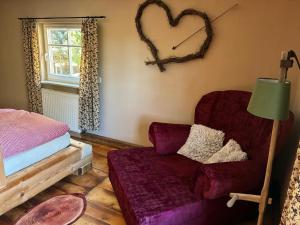 a bedroom with a couch and a heart on the wall at Ferienhaus Hutznhaisl in Bärenstein