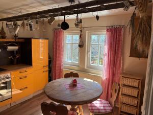 a kitchen with a table and a table and a window at Ferienhaus Hutznhaisl in Bärenstein