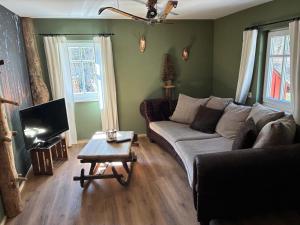 a living room with a couch and a coffee table at Ferienhaus Hutznhaisl in Bärenstein