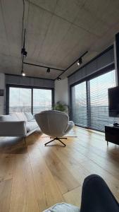 a large living room with a tub and a couch at Penthouse in Nowy Sącz