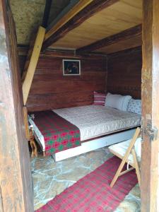 a bedroom with a bed in a wooden cabin at Seosko domacinstvo Gardic in Užice