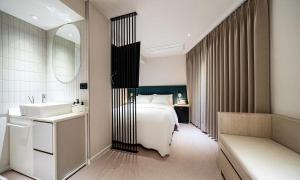 a bedroom with a bed and a sink and a mirror at 신촌 APL Hotel in Seoul