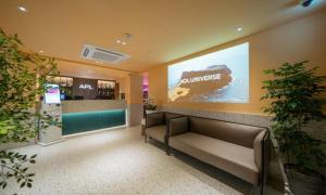 a waiting room with couches and a large sign on the wall at 신촌 APL Hotel in Seoul