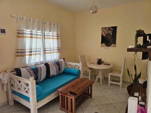 a living room with a blue couch and a table at Orange apartment 1 in Watamu