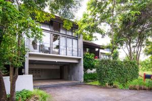an apartment building with a balcony and trees at The Vineyard Hideaway Khaoyai in Ban Wang Phaem