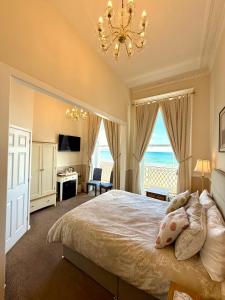 a bedroom with a large bed with a chandelier at The Angove - Adults Only in Weymouth