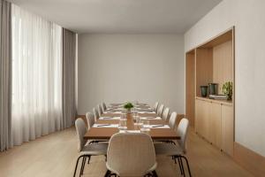 a long dining room with a long table and chairs at The Lake Como EDITION in Griante Cadenabbia