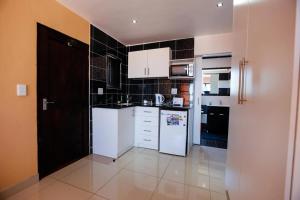 a kitchen with white appliances and black tiles at Grand View B&B in Johannesburg