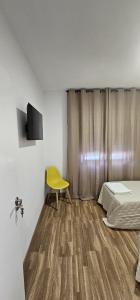 a room with a bed and a yellow chair at Apartamento San Simón in Redondela