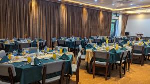 a conference room with tables and chairs with blue tablecloths at Balishira Resort Ltd. in Sreemangal +73 photos
