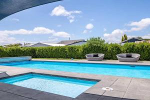 a swimming pool with blue water in a yard at Stonehenge Retreat in Martinborough