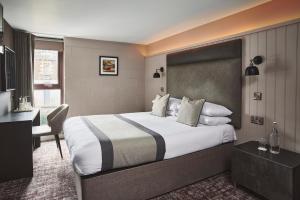 a hotel room with a large bed and a desk at The Ranald Hotel in Oban
