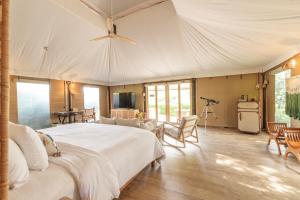 a bedroom with a large white bed and a tv at The Vineyard Hideaway Khaoyai in Ban Wang Phaem