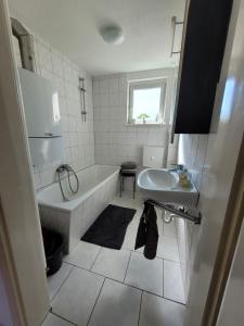 a white bathroom with a tub and a sink at Charlotte II in Neustadt bei Coburg