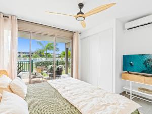 a bedroom with a bed with a ceiling fan at Ocean Breeze, Fully Renovated Beachfront 2 bdr in Baie Nettle +16 photos