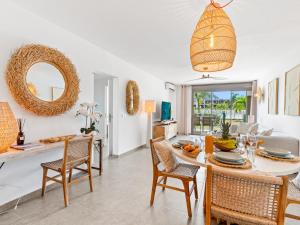 a dining room and living room with a table and chairs at Ocean Breeze, Fully Renovated Beachfront 2 bdr in Baie Nettle