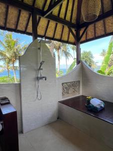 a bathroom with a shower and a bench in a room at The Palms - Seraya Shores Retreat Bali in Seraya