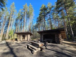 a log cabin in a forest with trees at Mudita Apartment in Mikkeli