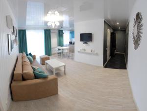 a living room with a couch and a table at Люкс с 2-мя спальнями в ЦЕНТРЕ in Mykolaiv