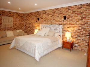 a bedroom with a bed and a brick wall at The Honeypot in Balmoral