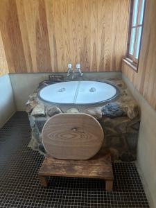 a bathroom with a tub and a sink at 掘っ立て小屋遊々 in Mine