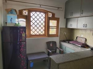 eine Küche mit einem schwarzen Kühlschrank und einem Fenster in der Unterkunft Bashaw Residency Top Rated In Srinagar Only 6 Kms from Srinagar International Airport And Only 5 Kms From Srinagar Railway Station in Srinagar
