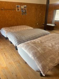 two beds sitting next to each other in a room at 掘っ立て小屋遊々 in Mine