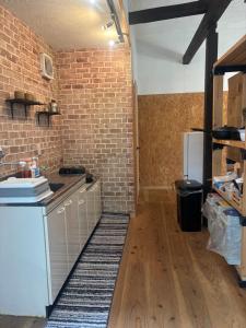 a kitchen with a counter and a brick wall at 掘っ立て小屋遊々 in Mine