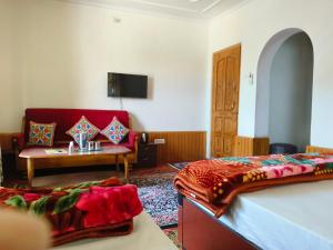 ein Zimmer mit einem Bett, einer Couch und einem Tisch in der Unterkunft Bashaw Residency Top Rated In Srinagar Only 6 Kms from Srinagar International Airport And Only 5 Kms From Srinagar Railway Station in Srinagar