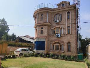 ein altes Backsteingebäude mit einem Uhrturm auf dem Dach in der Unterkunft Bashaw Residency Top Rated In Srinagar Only 6 Kms from Srinagar International Airport And Only 5 Kms From Srinagar Railway Station in Srinagar